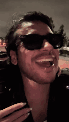 A Close Up Of A Man Wearing Sunglasses And A Leather Jacket GIF
