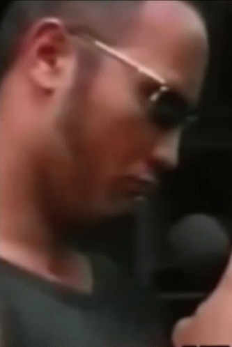 A Close Up Of A Man Wearing Sunglasses And A Microphone . GIF