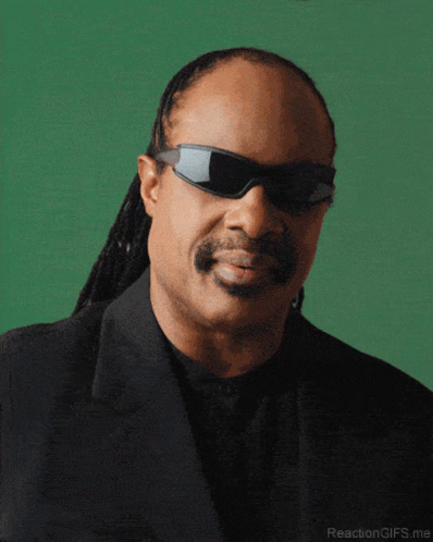 A Close Up Of A Man Wearing Sunglasses And A Suit GIF