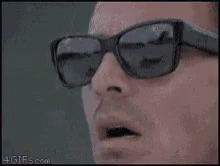 A Close Up Of A Man Wearing Sunglasses And Looking At Something . GIF