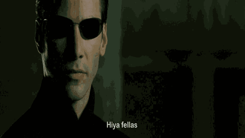 A Close Up Of A Man Wearing Sunglasses With The Words Hiya Fellas Written Below Him GIF