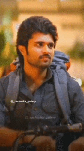 A Close Up Of A Man With A Backpack And The Name Rashmika Gallery On The Bottom Right GIF