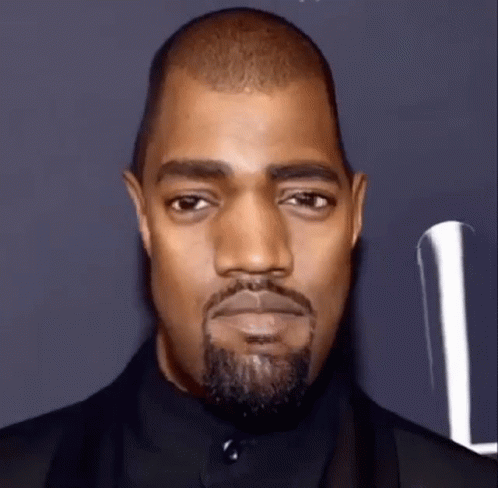 A Close Up Of A Man With A Beard And A Black Suit . GIF