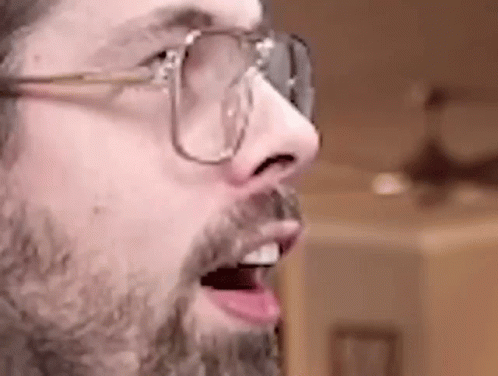 a close up of a man with a beard and glasses .