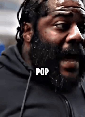 A Close Up Of A Man With A Beard And The Word Pop Written On His Face . GIF