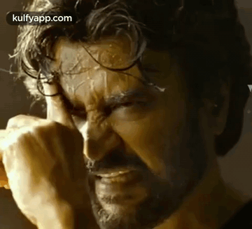 A Close Up Of A Man With A Beard Covering His Face With His Hands . GIF