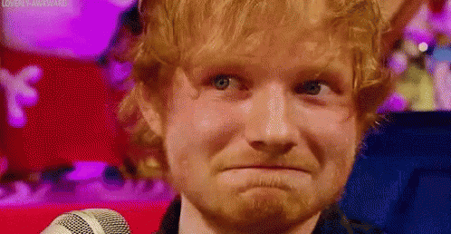 A Close Up Of A Man With A Beard Making A Funny Face While Standing In Front Of A Microphone . GIF