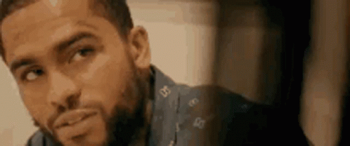 a close up of a man with a beard wearing a blue shirt .