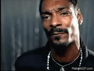 A Close Up Of A Man With A Beard Wearing A Necklace . GIF