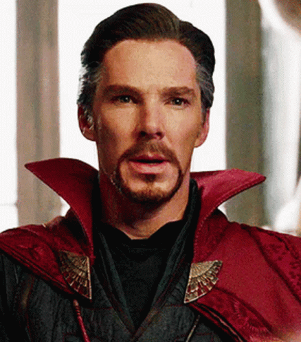 a close up of a man with a beard wearing a red cape and a black shirt .