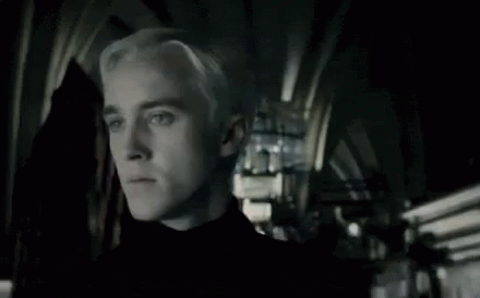 A Close Up Of A Man With Blonde Hair In A Dark Room . GIF