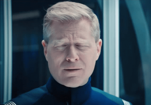 A Close Up Of A Man With His Eyes Closed In A Blue Uniform GIF