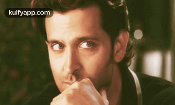 A Close Up Of A Man With His Hand On His Chin . GIF