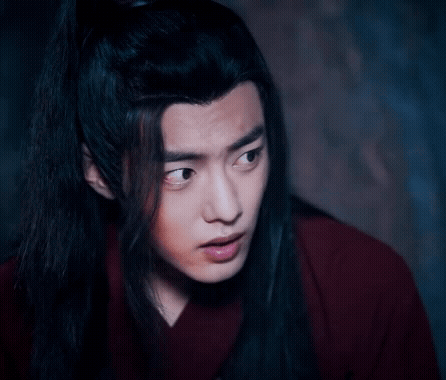 A Close Up Of A Man With Long Black Hair Wearing A Red Shirt . GIF
