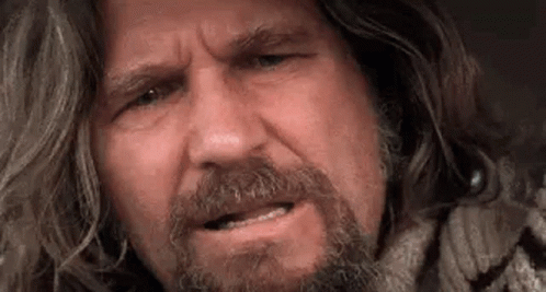A Close Up Of A Man With Long Hair And A Beard Making A Face . GIF