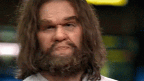 A Close Up Of A Man With Long Hair And A Beard Making A Funny Face . GIF