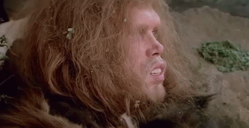 A Close Up Of A Man With Long Hair And A Fur Coat On . GIF