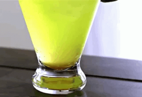 A Close Up Of A Martini Glass With A Green Liquid In It GIF