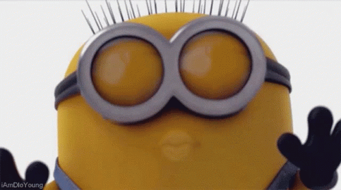 A Close Up Of A Minion Wearing Goggles And Giving A Kiss GIF