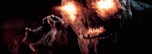 A Close Up Of A Monster With Glowing Eyes And Teeth GIF