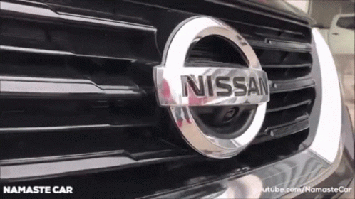 A Close Up Of A Nissan Logo On The Front Of A Black Car GIF