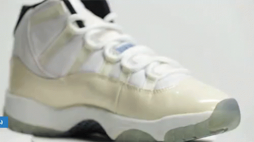 A Close Up Of A Pair Of White And Grey Sneakers On A White Surface . GIF