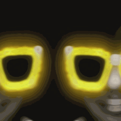 A Close Up Of A Pair Of Yellow Glasses With A Dark Background GIF