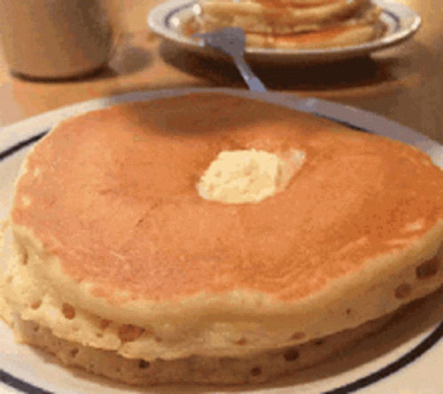 A Close Up Of A Pancake With Butter On Top On A Plate GIF
