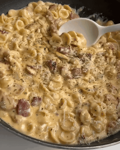 A Close Up Of A Pasta Dish With A Spoon In It GIF