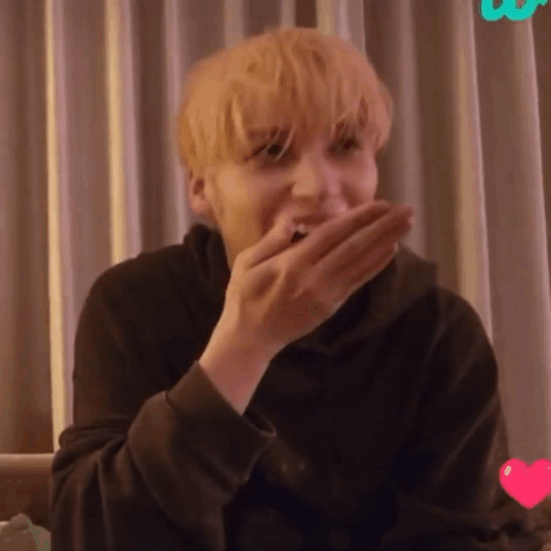 A Close Up Of A Person Covering Their Mouth With Their Hand GIF