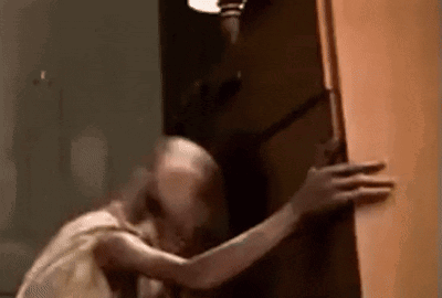 A Close Up Of A Person Holding A Door In A Room . GIF