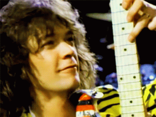 A Close Up Of A Person Holding A Guitar With A Nasa Logo On His Shirt GIF