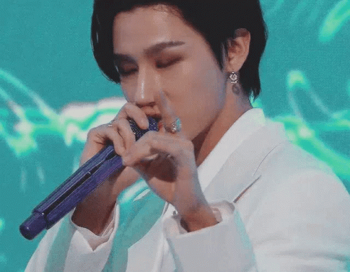 A Close Up Of A Person Holding A Microphone . GIF