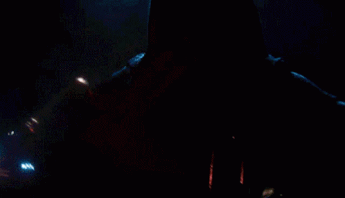 A Close Up Of A Person Holding A Red Light Saber In The Dark GIF