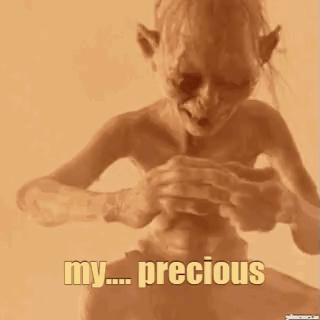 A Close Up Of A Person Holding A Small Object In Their Hand With The Words `` My Precious '' Written On It . GIF