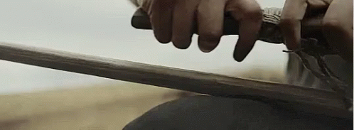 A Close Up Of A Person Holding A Sword . GIF