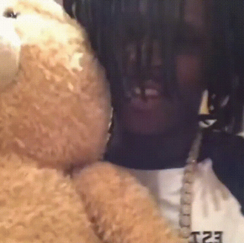 A Close Up Of A Person Holding A Teddy Bear With The Letters T23 On The Back GIF