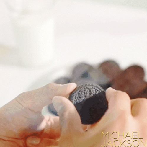 A Close Up Of A Person Holding An Oreo Cookie With Michael Jackson Written On The Bottom Right GIF