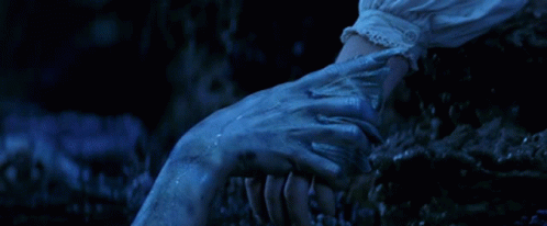 A Close Up Of A Person Holding Another Person 'S Hand In The Dark GIF