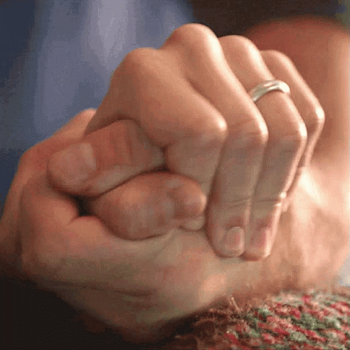 A Close Up Of A Person Holding Another Person 'S Hand With A Ring On Their Finger GIF