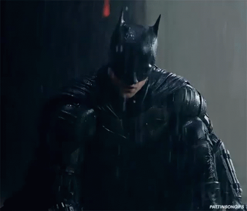 A Close Up Of A Person In A Batman Costume In The Rain GIF