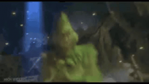 A Close Up Of A Person In A Green Costume Laying On The Ground . GIF