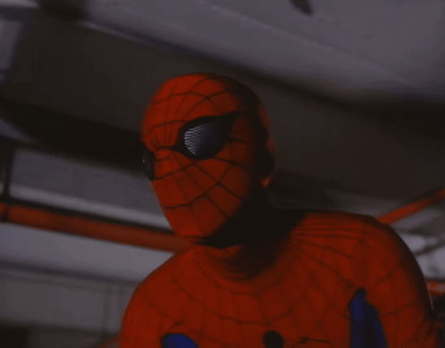 A Close Up Of A Person In A Spiderman Costume Holding A Gun GIF