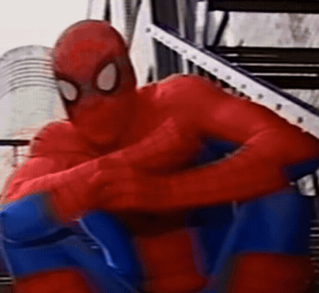 a close up of a person in a spiderman costume sitting on a staircase .