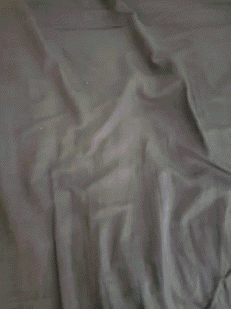 A Close Up Of A Person Laying On A Bed Covered In Sheets GIF