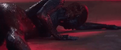 A Close Up Of A Person Laying On The Floor In A Dark Room With A Red Light Behind Them . GIF