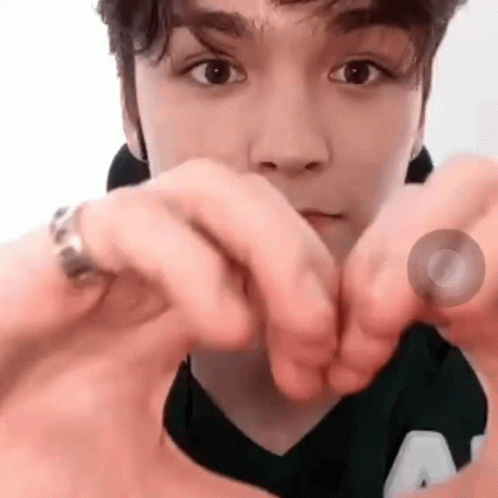 A Close Up Of A Person Making A Heart With Their Hands . GIF