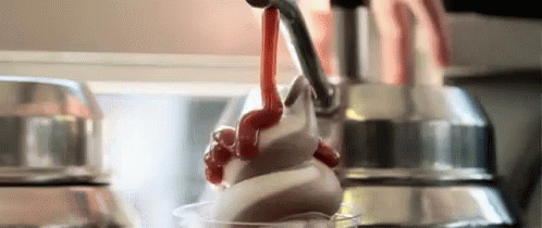 A Close Up Of A Person Pouring Whipped Cream Into A Cup . GIF