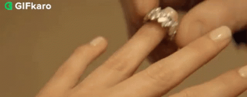 a close up of a person putting a ring on another person 's finger .