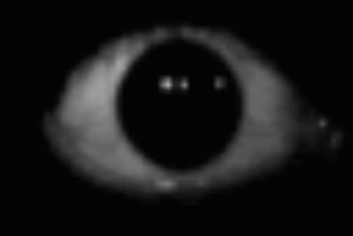 A Close Up Of A Person 'S Eye In The Dark With A Smiley Face On It . GIF